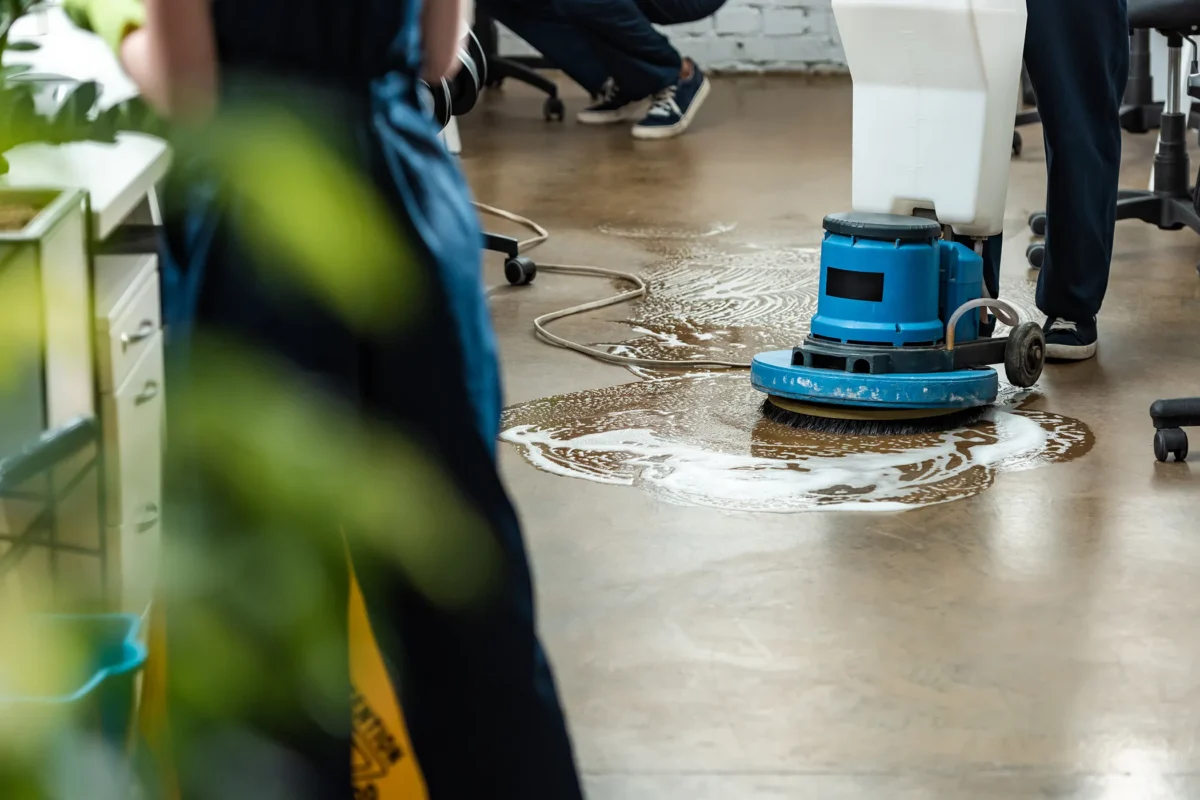 Reinigungsmaschine säubert einen nassen Fußboden in einem Bürobereich